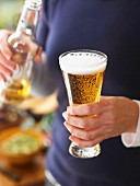Mann mit Sagres-Bier in Bierglas und Bierflasche (Portugal)