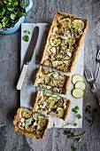 Savoury blue cheese and courgette tart topped with walnuts, sliced