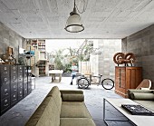 Offener Wohnraum mit Vintagemöbeln im Haus aus Beton