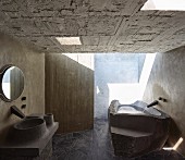 Béton brut in bathroom; bathtub and sink made from moulded concrete