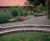 Garden with granite paving and shrub bed