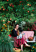 Frau genießt den herbstlichen Garten