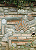 Kunstvoll gestaltete Steinmauer aus Kieselsteinen