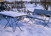 Verschneiter Garten mit Bank und Tisch