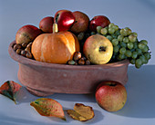 Bowl with apples, grapes, pumpkin and nuts