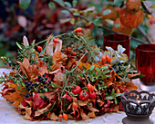 Herbstkranz aus diversen Blättern, Ligusterbeeren, Rosa / Hagebutten, Lärchenzwei