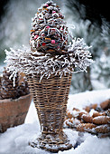 Willow basket vase with pine cones in hoar frost