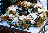 Christmas wreath with decorative roses, nuts, stars and pearl necklace
