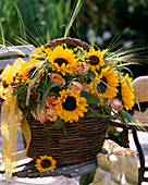 Wicker basket with Helianthus annuus (sunflowers, roses)
