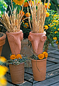 Clay heads with grasses, Tagetes (marigold)