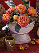 Bowl with pink (rose petals), gold cup, tree ornaments, terracotta cones in the rough