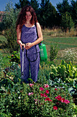 Woman spraying against pests in the cottage garden