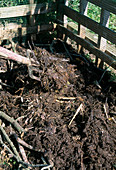 Aufbau eines Kompostes - Bedecken der ersten Schicht mit altem Kompost (2/8)