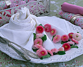 White napkin with bellis (daisies) in pink