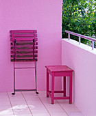 Leerer Balkon mit pinkem Beistelltisch und pinkem Klappstuh