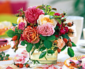 Pink (rose) and rosehip in glass vase