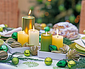 Kerzen in Grün und Weiß in weißem Porzellanuntersetzer
