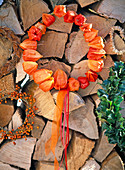 Kranz aus Physalis (Lampion) mit orangem und pinkem Schleifenband