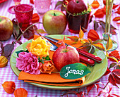 Tellerdekoration mit Apfel und Rosenblüten, Blatt mit Namen als Platzkarte für Jonas