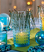Blaues Glas als Windlicht dekoriert mit Pinus (Kiefernnadeln), Kugelkränzchen