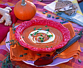 Pumpkin soup in red plate