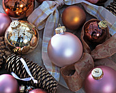 Tree ornaments, baubles in pink, orange, brown and gold, spruce cones