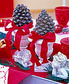 Cones of Pinus (pine) in small cups with red ribbon