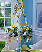 Hanging metal wreath over table with narcissus (daffodils)