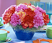 Gesteck aus Dianthus (Nelken, rot und rosa) mit Sisalmanschette