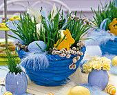Osternest in blauer Schale mit Triticum (Weizen), Ostereiern, Filzhasen