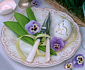 Festliche Tischdekoration mit Grasläufer und Stiefmütterchenblüten