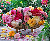 Rosengesteck in englischem Gartenkorb mit Beetrosen (gelb, rosa)