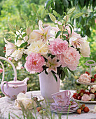 Strauß aus Paeonia (Pfingstrosen) und Lilium (Lilien) in weißer Vase