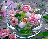Rosa Blüten von Rosa (Rosen), Clematis (Waldrebe), weiße Schwimmkerzen