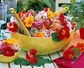 Salad with edible flowers in light green skin