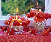 Small physalis wreaths around lanterns filled with pearls