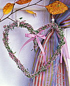 Heart-shaped wreath made of Calluna (broom heather) with pink ribbon