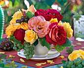 Strauß aus Rosa (Rosen) in gelb, orange und rot, Vitis (Weintrauben)