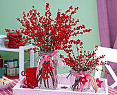 Bouquets of Ilex verticillata (red winterberry) in glass vase