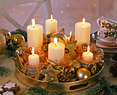 Abies (Tanne), Pinus (Kiefern), weiße Kerzen auf goldenem Tablett