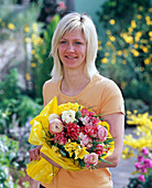 Frau mit Strauß aus Ranunculus (Ranunkeln), Tulipa (Tulpen), Vaccinium