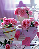 Pink (roses) in heart vases on the table, sign in heart shape