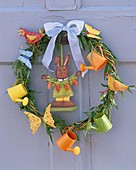 Door wreath decorated with Easter bunny, small watering cans and butterflies