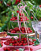 Etagere with prunus (cherries) and ribbons on the table, glasses