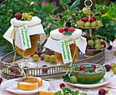 Gläser mit Marmelade aus Ribes (Stachelbeeren) mit weißem Tuch und Beeren