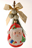 Weihnachtsmann als Weihnachtsbaumschmuck mit Weihnachtsbaumkugeln und Schleife
