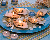 Plate of mussels and conch-candles on sand