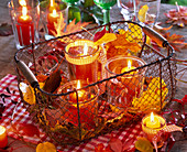 Lanterns in a basket with autumn leaves