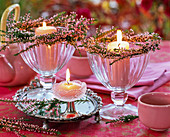 Kleine Kränze aus Calluna (Besenheide) um Eisbecher mit rosa Kerzen