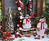 Terrace near Christmas tree made of pieces of wood and branches, snowmen